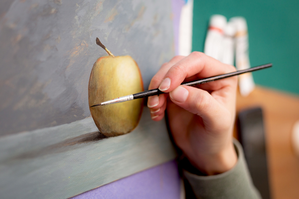 paiting an apple with a small pointed brush